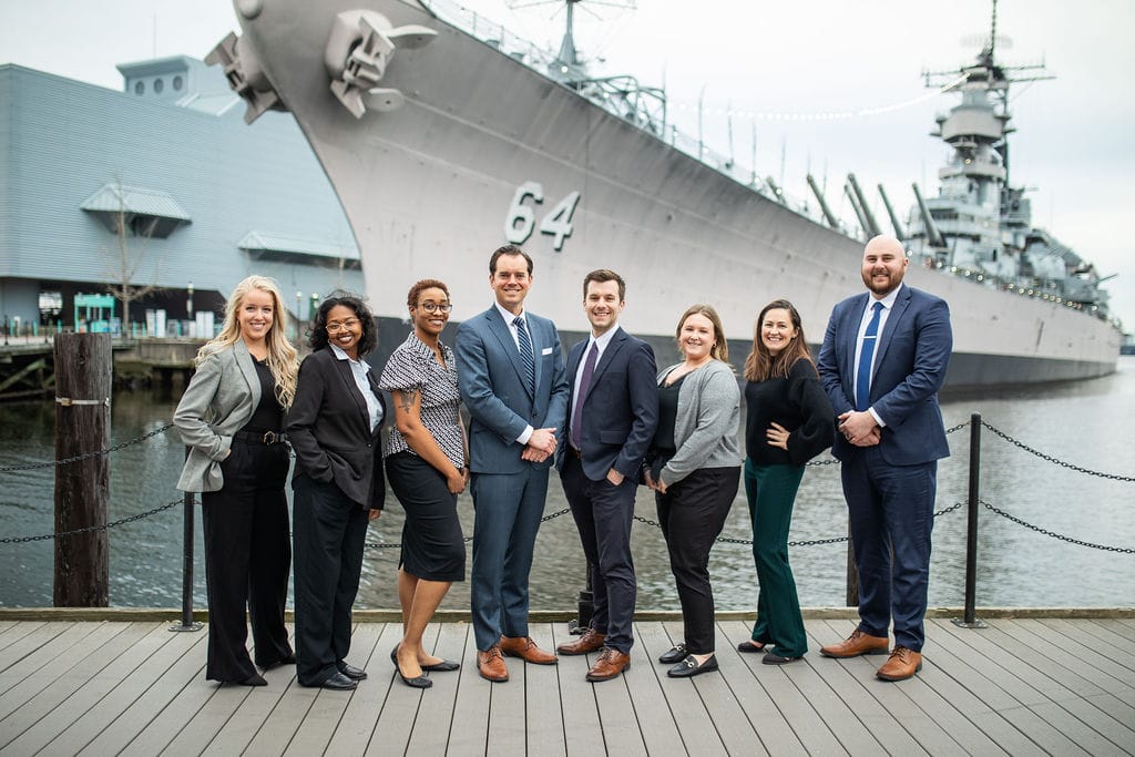 The McCormick Law & Consulting team on the Norfolk waterfront with the USS Wisconsin